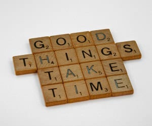 Scrabble pieces that spell "good things take time," just as networking - you have to play the long game