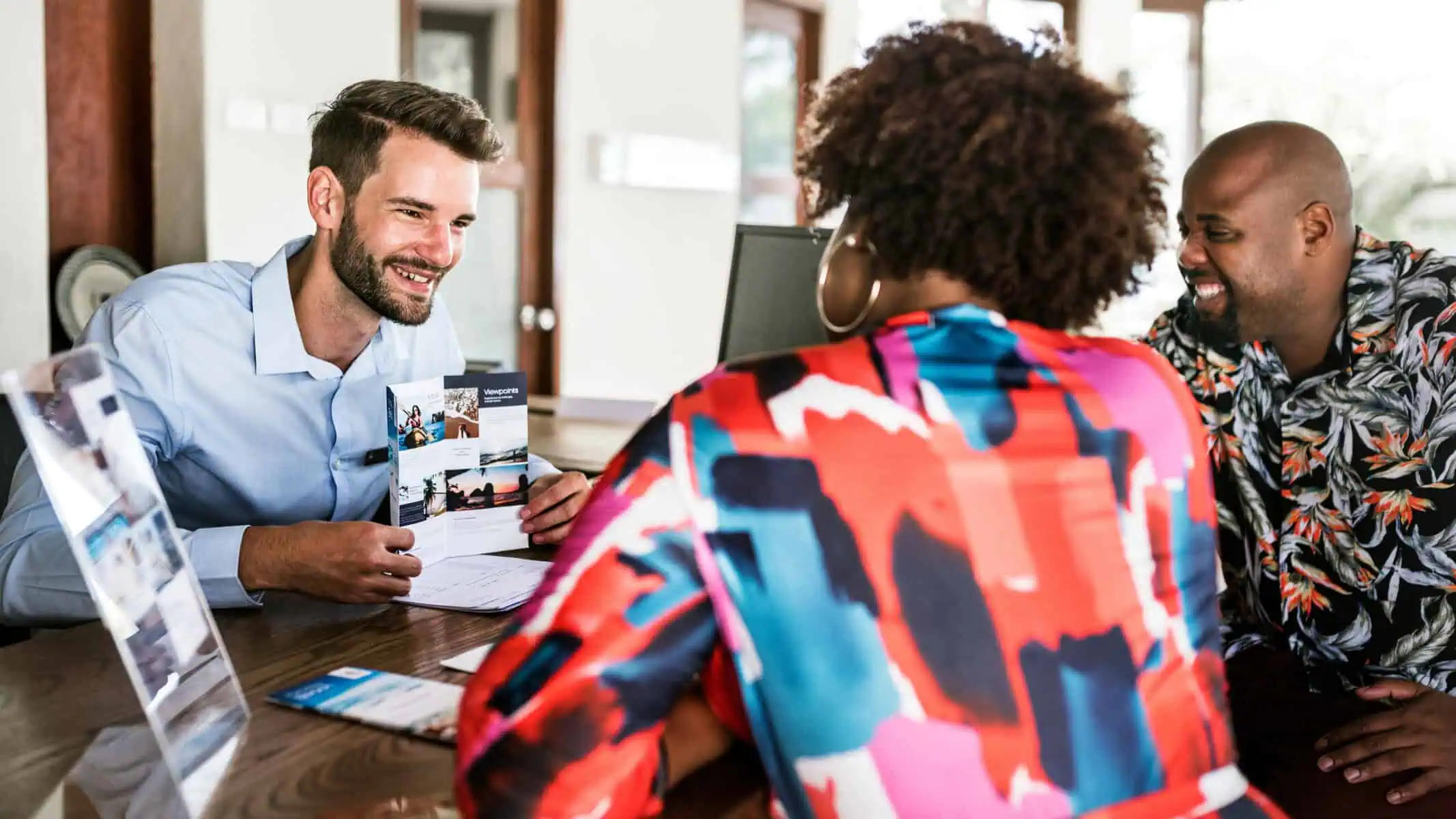 couple reviewing a print sales brochure with sales team