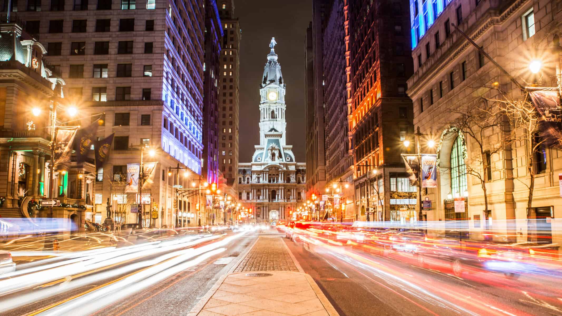 Philadelphia City Hall at night with print banners on sidewalk lights