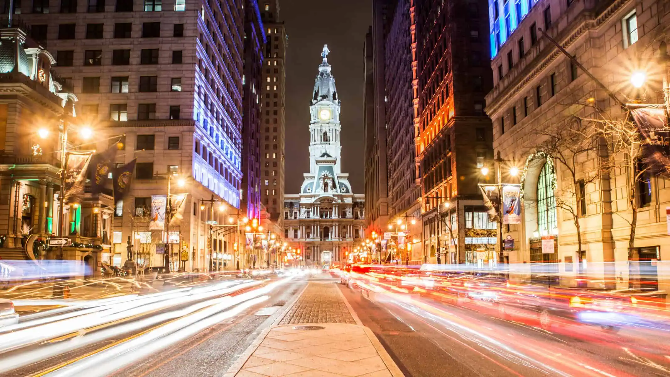 Philadelphia City Hall at night with print banners on sidewalk lights